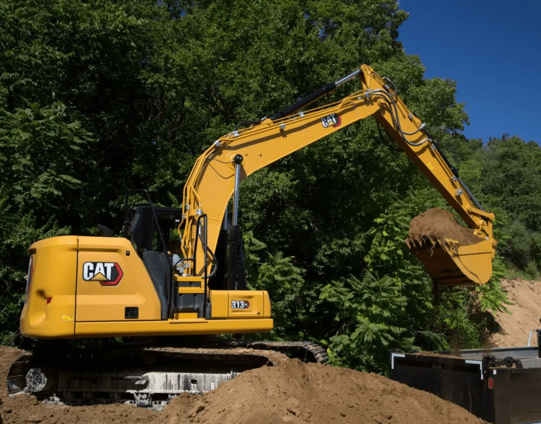 CAT excavator dumping dirt into dump truck
